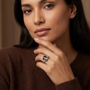 Cushion smoky quartz ring styled with layered gemstone rings on hand