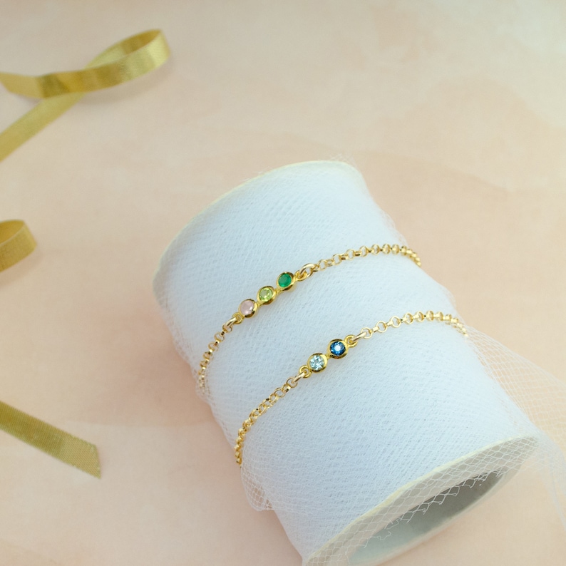 Two gold minimalist bracelets on a roll of lace. Mothers Day bracelet, mother of one, mother of two jewelry, zodiac birthstone jewelry, leo birthstone bracelet, jewelry for virgo, sagittarius, taurus, aries, scorpio, cancer, capricorn, stone bracelet