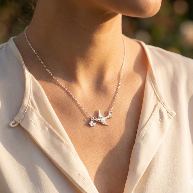 Model wearing the bird family necklace, delicate everyday layering look, personalized initial charm necklace for mom, minimalist mother’s necklace in sterling silver tone.