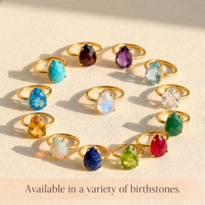 Collection of teardrop gemstone rings in multiple birthstone colors, showing moonstone with other stones in gold settings. A variety image for birthstone rings, June birthstone ring, personalized gemstone jewelry, birthday gifts, and colorful statement rings.