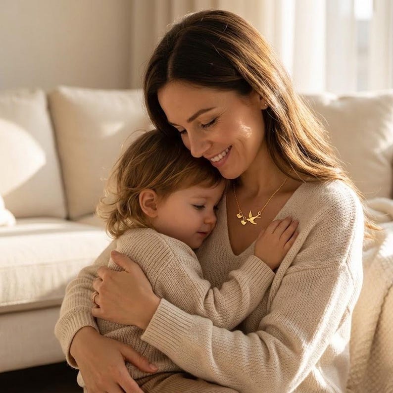 Cozy motherhood lifestyle photo, mom wearing family necklace while holding baby, personalized initials for kids, meaningful gift for new moms.