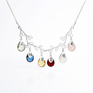 May include: Silver necklace with a branch design and six teardrop-shaped crystals. Each crystal has a letter engraved on it: C, N, S, J, E, and K.