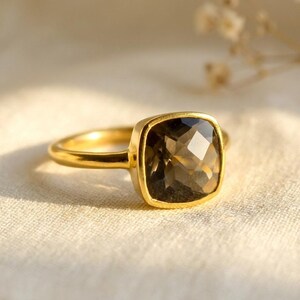 Smoky quartz ring close-up showing faceted cushion stone and bezel setting