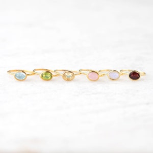 6 gold gemstone rings in a row. Blue topaz ring, Peridot ring, Citrine ring, Pink Chalcedony ring, Moonstone ring, Garnet ring, blue stone, green stone, yellow stone, pink stone, moonstone, red stone, white stone ring, gemstone ring set