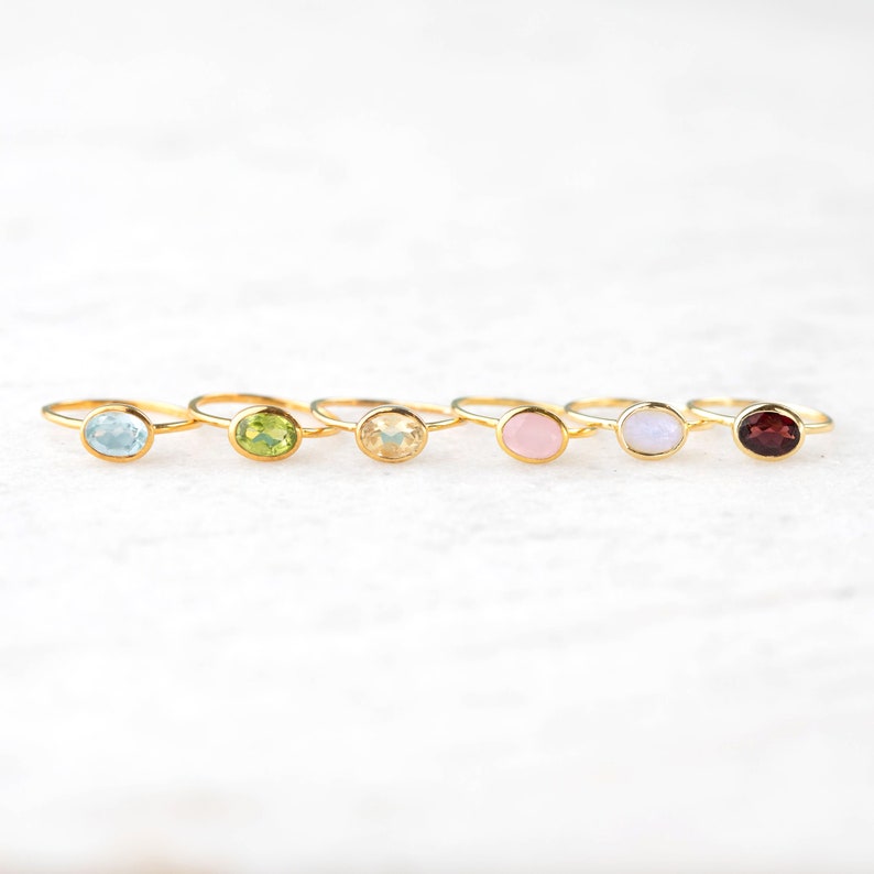 6 gold gemstone rings in a row. Blue topaz ring, Peridot ring, Citrine ring, Pink Chalcedony ring, Moonstone ring, Garnet ring, blue stone, green stone, yellow stone, pink stone, moonstone, red stone, white stone ring, gemstone ring set