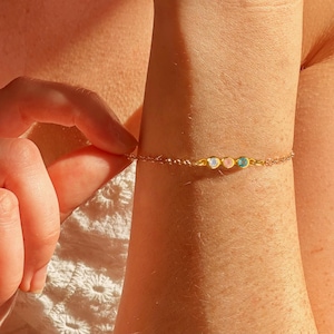Zoomed-in view of a dainty personalized birthstone bracelet featuring three natural bezel-set gemstones on a gold filled chain. This custom bracelet makes a perfect gift for mom, grandma, daughter, or best friend. Ideal for Mother’s Day, birthdays, anniversaries, or graduation. A minimalist and meaningful piece of handmade jewelry for women, showcasing family birthstones in a timeless, elegant design. Available in sterling silver, gold, or rose gold.