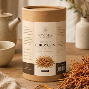 Può includere: Un contenitore cilindrico in cartone marrone etichettato Mycora Natural Goods Gedroogde Cordyceps 100% Cordyceps Militaris. L'etichetta presenta testo in olandese, un'illustrazione di fungo e un peso di 50 grammi. Cordyceps essiccati arancioni si trovano accanto.