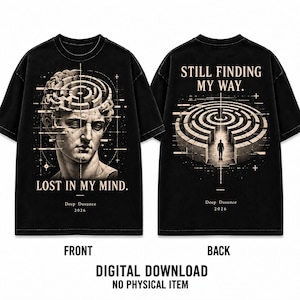 Könnte beinhalten: Ein schwarzes T-Shirt mit einer Grafik auf der Vorderseite, die einen klassischen Statuenkopf mit einem Labyrinth im Gehirn und den Text LOST IN MY MIND zeigt. Die Rückseite zeigt eine Person vor einem großen Steinlabyrinth mit dem Text STILL FINDING MY WAY.