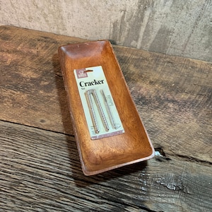 May include: A wooden serving tray with a package of three silver nutcrackers inside. The package is labeled "Cracker Set".