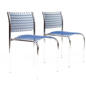 May include: Two chrome chairs with blue mesh seats and backs. The chairs are modern and minimalist in design.