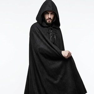 May include: A floor-length black hooded cloak featuring a textured fabric finish. The garment includes a deep hood and a front closure system consisting of black cord lacing threaded through metal eyelets at the neckline, creating a secure fit.
