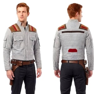 Könnte beinhalten: Eine hellgraue Jacke mit hohem Kragen, braunen Schulterpartien mit roten Streifen und Brusttaschen. Das Outfit umfasst eine dunkelanthrazitfarbene Hose und einen braunen Ledergürtel mit Holster, getragen mit braunen Lederstiefeln.