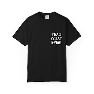 Może przedstawiać: Czarny t-shirt z krótkim rękawem z białym napisem na prawej piersi o treści YEAH WHAT EVER! wykonanym pogrubioną, geometryczną czcionką bezszeryfową. Odzież posiada okrągły dekolt i standardowy krój z widoczną metką przy kołnierzu.