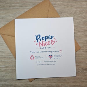 May include: A square white greeting card with a brown envelope. The card features the blue and pink text Proper Nice CARD CO. and the phrase Proper nice cards for every occasion. It includes a recycle icon, a UK flag heart, and 15 x 15 cm text.