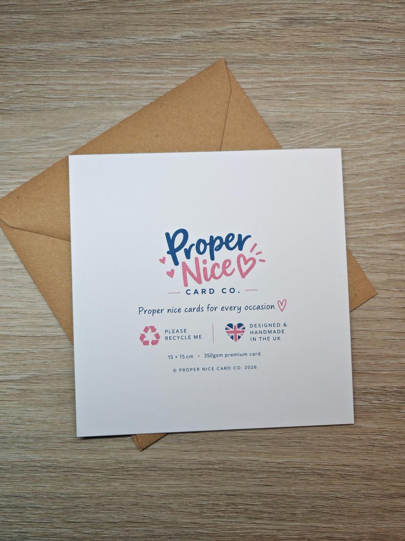 May include: A square white greeting card with a brown envelope. The card features the blue and pink text Proper Nice CARD CO. and the phrase Proper nice cards for every occasion. It includes a recycle icon, a UK flag heart, and 15 x 15 cm text.