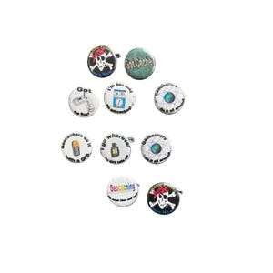 May include: A collection of ten circular pin-back buttons featuring various geocaching-themed designs, including skull and crossbones with text, GPS device illustrations, and text phrases like Got Cache, I'm not lost, and Geocachers do it with a GPS.