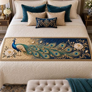 May include: A rectangular bed runner featuring a detailed peacock with blue and green plumage, gold accents, and white floral motifs on a split cream and navy blue quilted background. The design includes intricate embroidery and raised fabric textures.