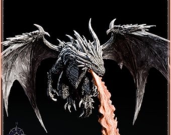 May include: A detailed black and silver dragon figurine with large, textured wings spread wide. The dragon is captured in a dynamic pose, exhaling a stream of orange-toned fire from its mouth. The creature features sharp, pointed scales and horns.