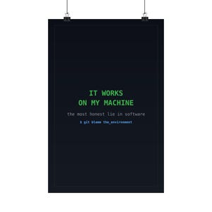 May include: A black rectangular wall poster featuring the green text IT WORKS ON MY MACHINE, followed by the white text the most honest lie in software, and the blue command line text $ git blame the_environment, suspended by two clips.