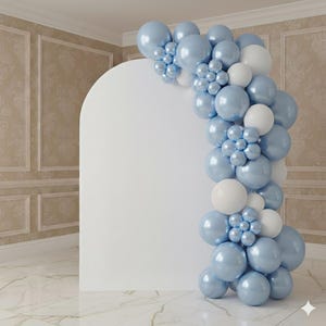 May include: A white arched backdrop panel decorated with a balloon garland featuring a mix of metallic light blue and matte white balloons. The balloons are arranged in clusters and individual sizes, creating a vertical display along the right side.