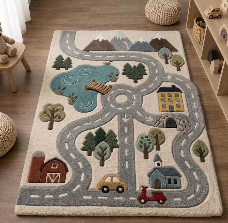 May include: A rectangular area rug featuring a tufted landscape design with a winding gray road, a blue lake with a wooden bridge, green trees, brown mountains, a red barn, a yellow house, a blue building, a yellow car, and a red scooter.