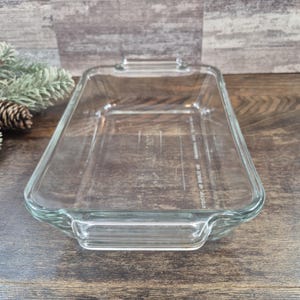 Puede incluir: Una fuente de horno rectangular de vidrio transparente con asas integradas en ambos extremos. El fondo de la fuente presenta un texto en relieve que dice: NO STOVETOP, NO BROILER USE, OVEN SAFE ONLY.