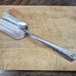 May include: A handmade wooden sign displaying the word "Welcome" in a whimsical font. The white-painted sign has a distressed finish and a small heart detail. Suitable for indoor or outdoor display.