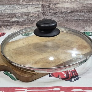 Glaslock, innerdiameter 23,5 cm, ytterdiameter 23,5 cm, rostfritt stål och svart knopp