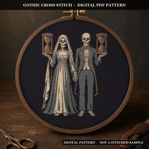 May include: A circular wooden embroidery hoop containing a cross stitch pattern of two skeletons, one in a gown and veil and one in a suit, each holding an hourglass. The text GOTHIC CROSS STITCH - DIGITAL PDF PATTERN and DIGITAL PATTERN - NOT A STITCHED SAMPLE is visible.