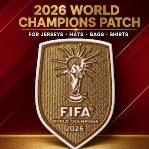 Puede incluir: Un parche bordado en forma de escudo en color dorado y blanco con el gráfico del trofeo FIFA World Champions 2026. El texto dice 2026 WORLD CHAMPIONS PATCH FOR JERSEYS, HATS, BAGS, SHIRTS, FIFA WORLD CHAMPIONS y 2026.