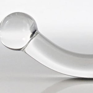 May include: A clear glass curved wand with two rounded ends.