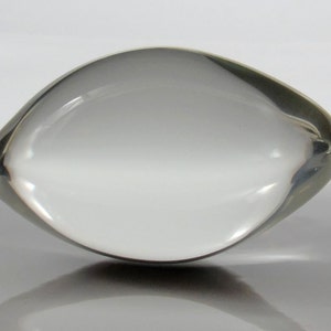 May include: A clear glass paperweight shaped like an eye.