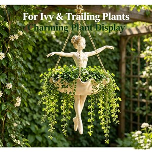 May include: A hanging planter featuring a cream-colored ballerina figurine holding a scalloped bowl filled with green trailing plants. The planter is suspended by gold-toned chains and includes the text For Ivy & Trailing Plants Charming Plant Display.