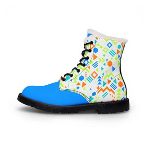 May include: A lace-up ankle boot featuring a bright blue toe and heel section, contrasted with a white upper panel decorated with a geometric pattern of orange, lime green, and blue shapes. The boot has black laces and a white faux-fur lining.