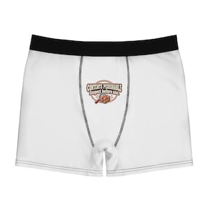 Könnte beinhalten: Weiße Boxershorts mit schwarzem Bund und schwarzen Nähten. Auf der Vorderseite befindet sich eine Grafik mit rotem Kreisrand, einer Lupe, einem kleinen braunen Karton und dem Text "CONTENTS PERISHABLE Inspect before use."