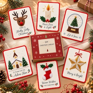 Peut inclure: Un kit de cartes de Noël DIY dans une boîte rouge avec des flocons blancs, entouré de six cartes brodées représentant un renne, une bougie, une boule à neige, une église, une chaussette et une étoile, avec des textes comme Have a Holly Jolly Christmas.