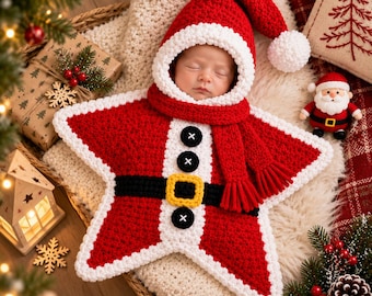 May include: A star-shaped crochet baby bunting in red and white, designed to resemble a Santa Claus suit. It features a hood with a white pom-pom, a black belt with a yellow buckle, and three black buttons down the centre, with a red scarf attached.