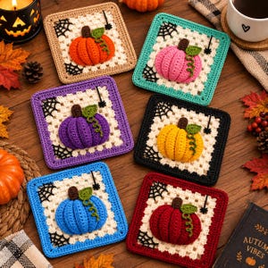 Op de afbeelding: Zes vierkante gehaakte onderzetters met een centrale 3D-pompoen in oranje, roze, paars, geel, blauw en rood. Elke onderzetter heeft een witte granny square rand, zwarte spinnenwebaccenten in de hoeken en een kleine zwarte spin.