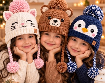 May include: Three crocheted beanies featuring animal designs: a white cat with pink ears and pom-poms, a brown bear with rounded ears and a top pom-pom, and a dark blue penguin with a white face, yellow beak, and a blue and white pom-pom.