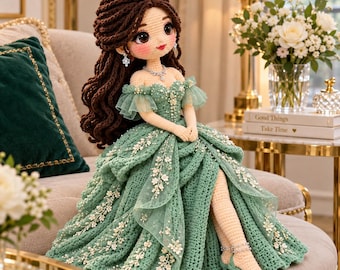 May include: A handcrafted crochet doll with long wavy brown hair, wearing a sage green off-the-shoulder gown adorned with white floral lace and pearl accents. The doll features a matching necklace, earrings, and green high-heeled sandals.