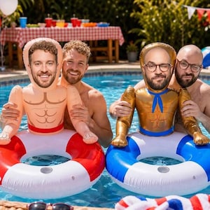 May include: Two inflatable pool floats featuring custom printed faces on the heads of muscular figures. One float has a red and white ring base, while the other has a blue and white ring base. Both figures have defined chest muscles and arms.