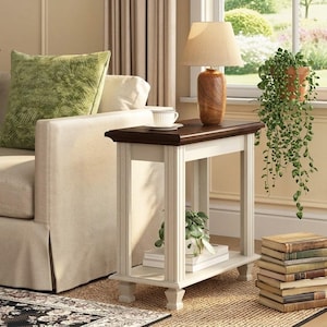 May include: A rectangular end table featuring a dark brown wooden top and a cream-colored base with four legs and a lower shelf. The table has a smooth finish and vertical detailing on the legs, providing a stable surface for items.
