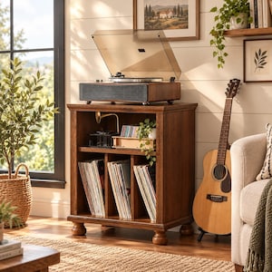 May include: A dark wood record player stand with a top surface holding a turntable with a clear dust cover. The unit features an open shelf with a small lamp and a lower section divided into three vertical compartments filled with vinyl records.