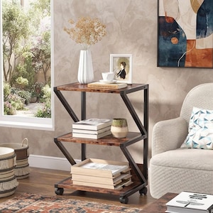 May include: A three-tier Z-shaped side table with a dark brown wood-grain finish and a black metal frame. The unit features three rectangular shelves and is supported by four small caster wheels at the base, allowing for mobility across the floor.
