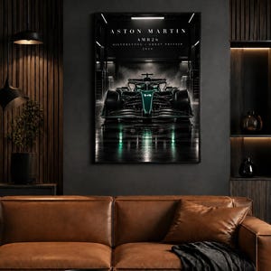 May include: A framed wall art print featuring a dark green Aston Martin AMR26 Formula One race car centered in a garage. The text reads ASTON MARTIN AMR26 SILVERSTONE GREAT BRITAIN 2026. The car is shown from the front with number 14 visible.