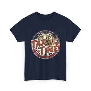 Può includere: Una t-shirt blu navy con una grafica circolare che riporta il testo "IT'S THAT SEASON! TAX TIME! CALCULATORS & COFFEE". Il design include una calcolatrice sorridente, monete d'oro e una pila di ricevute con le parole "RECEIPTS" e "DUES".