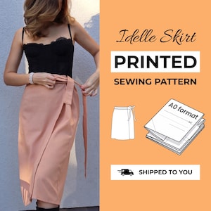 May include: A printed sewing pattern for an Idelle Skirt, featuring a peach-colored wrap skirt with a tie waist. The graphic includes the text Idelle Skirt, PRINTED SEWING PATTERN, A0 format, and a line drawing of the skirt design on an orange background.