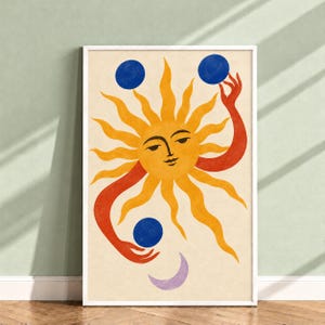 May include: A vertical wall art print on a cream background featuring a central yellow sun with a human face. Two red arms extend from the sun, each holding a solid blue circle. A small, light purple crescent moon sits at the bottom.