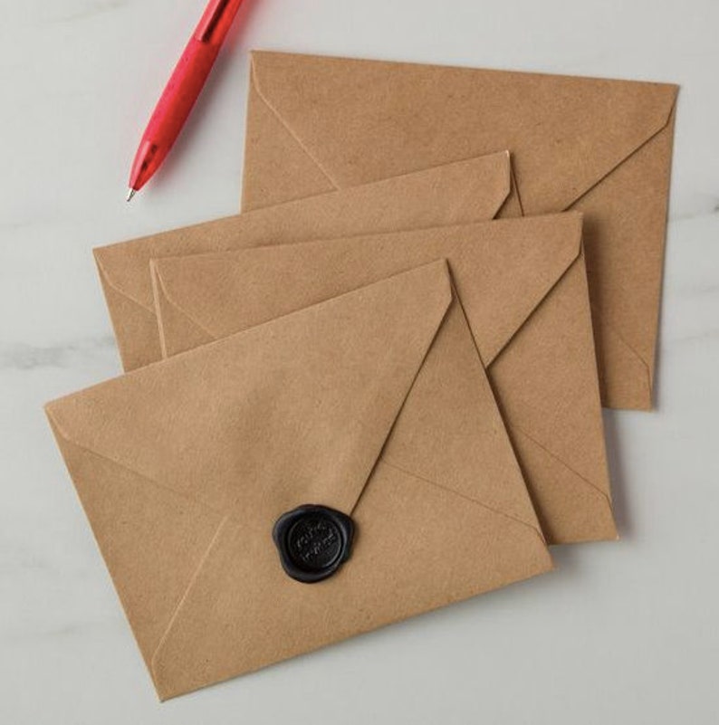 Pode incluir: Uma pilha de quatro envelopes de papel castanho com um selo de cera preto no envelope superior.