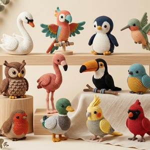 May include: A collection of eleven crocheted bird figures including a white swan, a colorful parrot, a penguin, a hummingbird, an owl, a pink flamingo, a toucan, a blue and yellow bird, a robin, a mallard duck, a cockatiel, and a red cardinal.